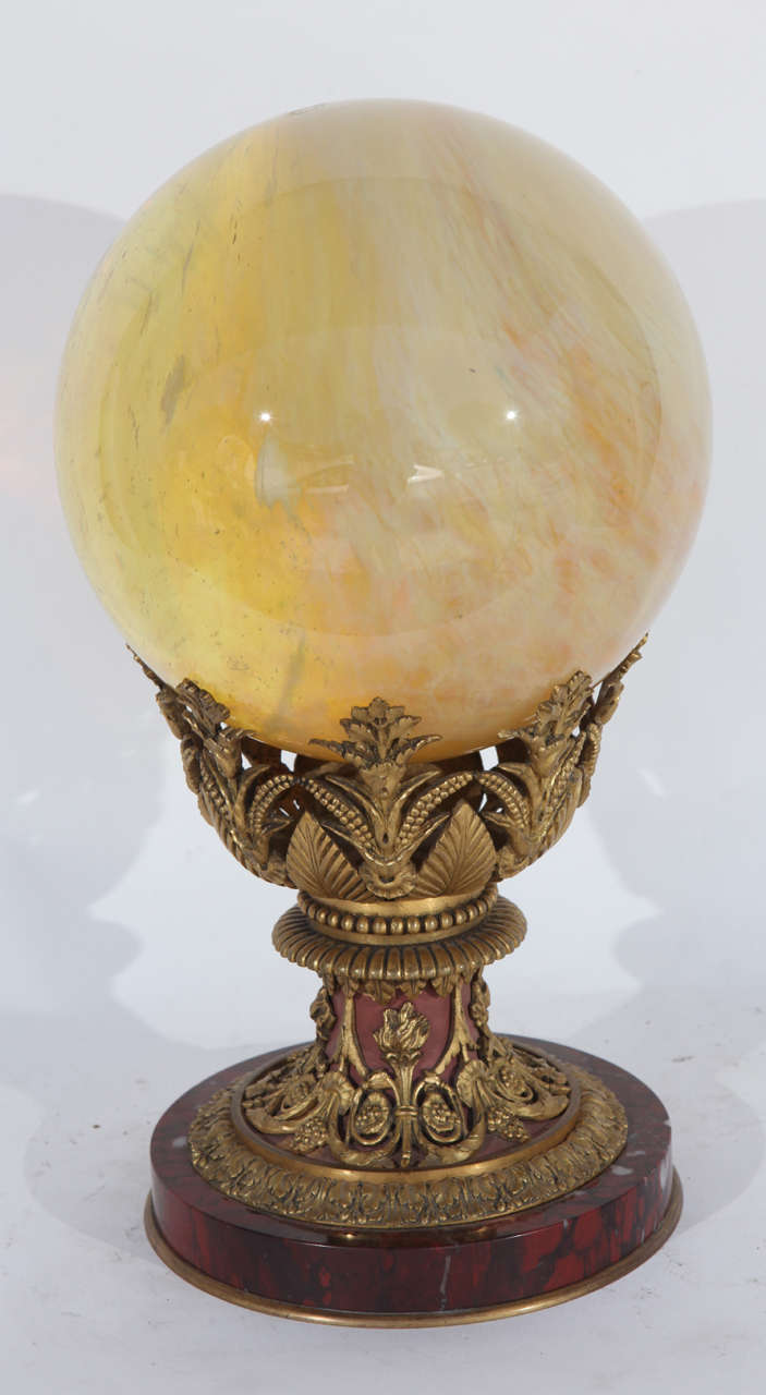 19th century French finely chased dore bronze rouge marble stand with an opalescent glass orb. There are two pieces as the orb and the marble stand are not attached. The orb diameter measures 8 inches. The diameter of the marble stand measures 6.75