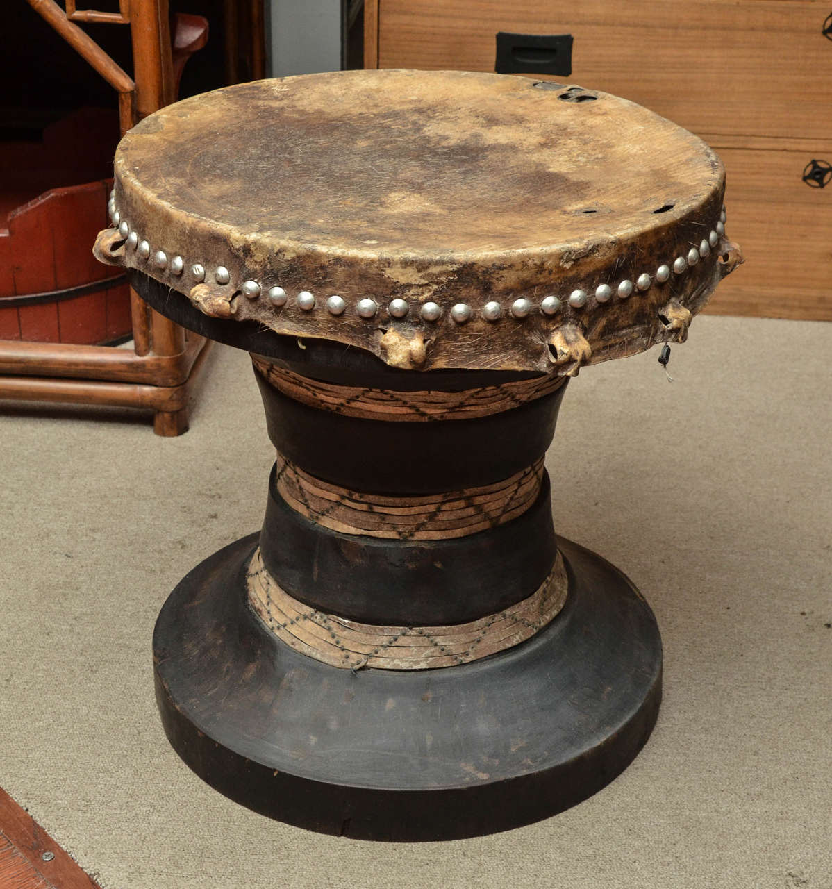 Turn of the century Thai ceremonial drum in carved wood, parchment and skin with bobble nail decoration.