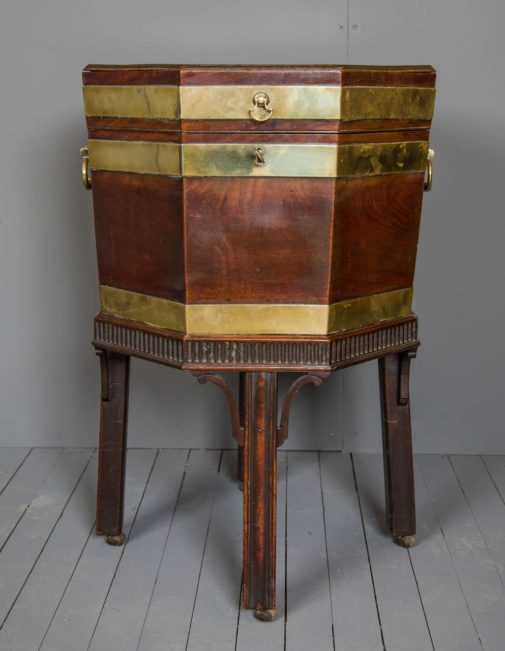 This superb quality George III mahogany wine cooler features a more unusual octagonal shape with decorative brass banding, a lovely patina and a double hinge on the back. The cooler has the original zinc lining, petitioned into seven sections, and