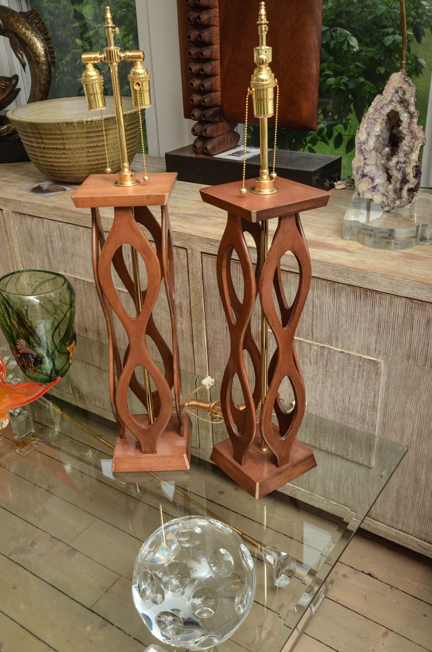 Pair of wood open-work table lamps with brass hardware.