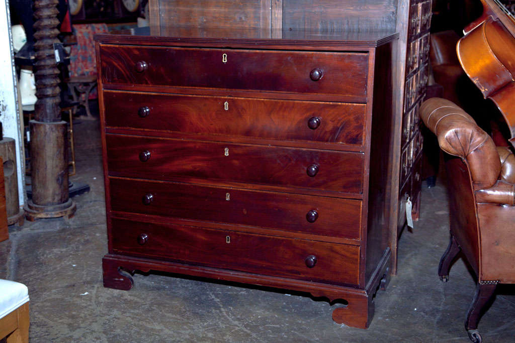 English mahogany chest of drawers, c. 1840, veneer on a mahogany carcass, crossbanded top over 5 long drawers on ogee bracket feet.