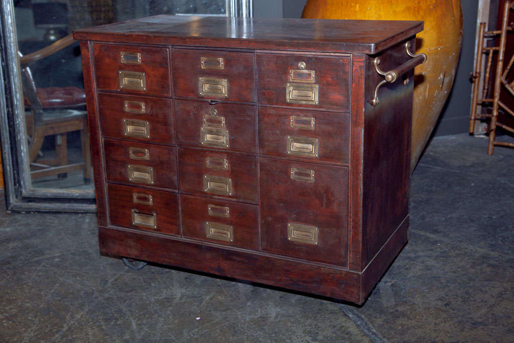 American industrial metal cabinet for filing with inset campaign hardware, 1906 patented bar locking mechanism, on castors with side pushing bars and with a beautiful burnished patina, c. 1900-20