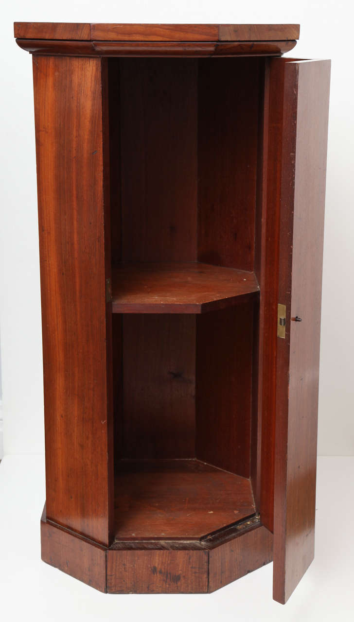 An English mahogany octagonal pedestal cabinet with concealed door,
circa 1830.
