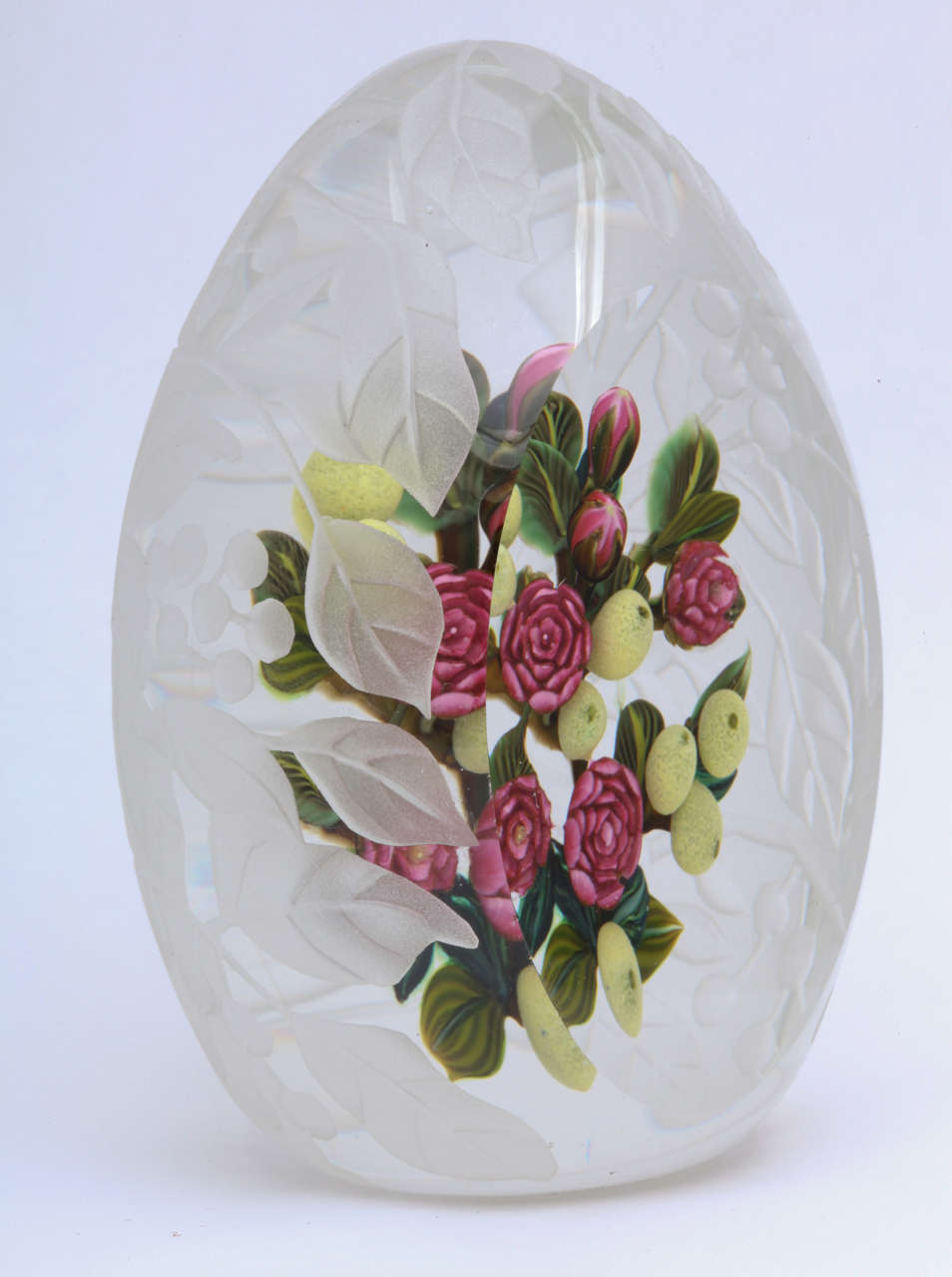 A beautiful Cathy Richardson egg-shaped paperweight sculpture from the Nostalgia series with red roses, yellow fruit and striped leaves, the outside carved with a flowering branch