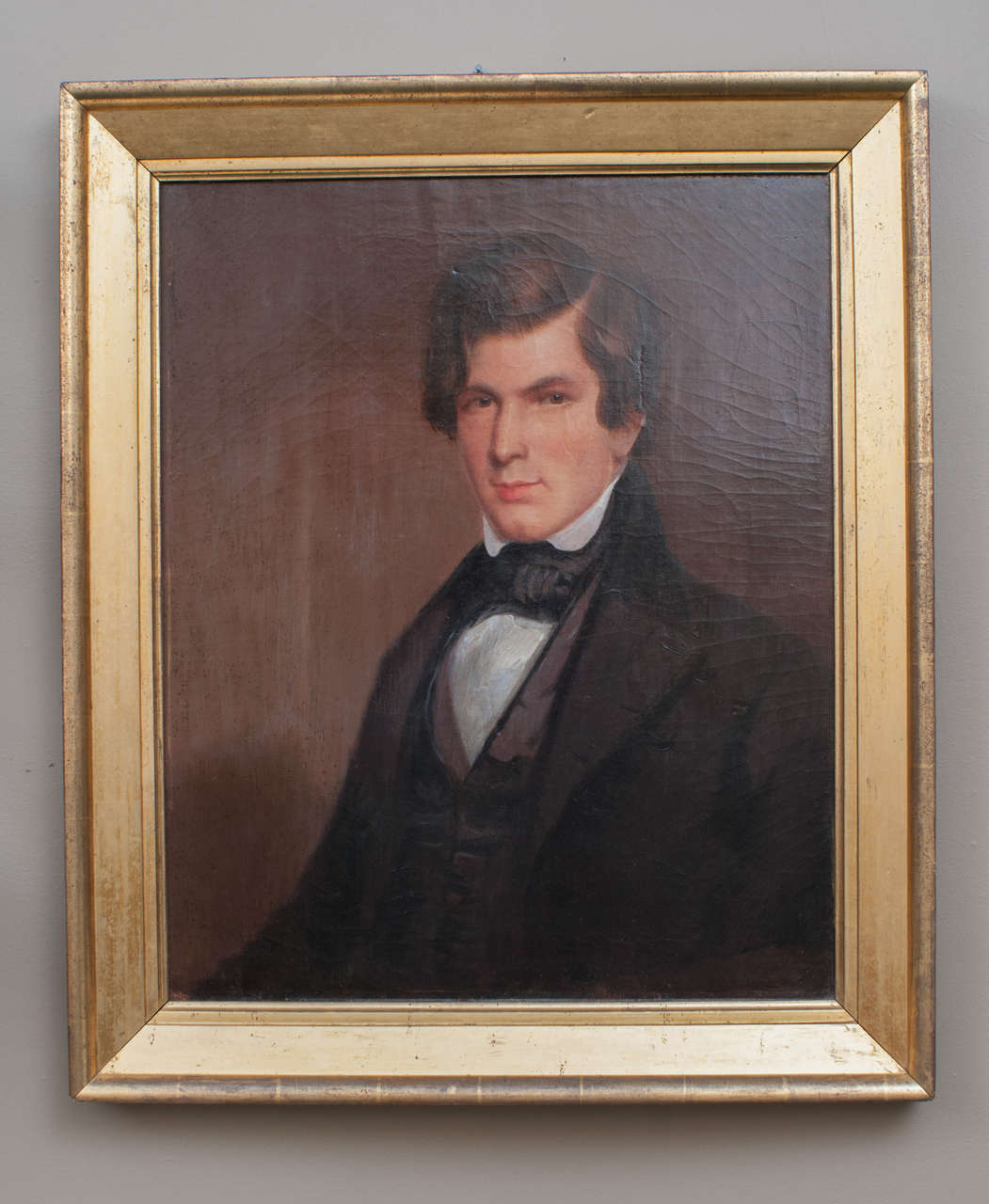 The hair style and clothing of this very serious and handsome fellow date this somewhat primitive painting to the late Antebellum period - excellent patina on both the portrait and the frame. The frame is probably original.