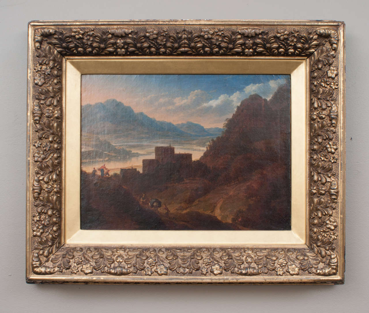 Mountain scene with a caravan heading toward a fortress overlooking a lake. Incredible clouds and blue sky. Written on back of canvas: 