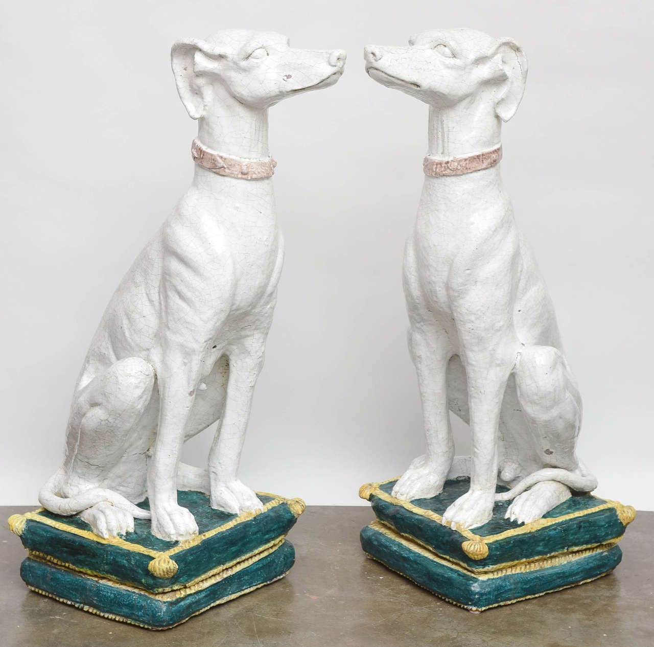Pair of French monumental glazed terracotta male & female greyhounds sitting on tasseled pillows. Exceptional size and detail with wonderful crazing.