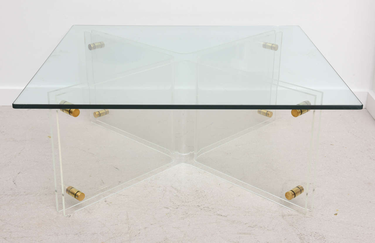 Mid-Century Modern Lucite coffee table with brass connector hardware and rectangular glass top.