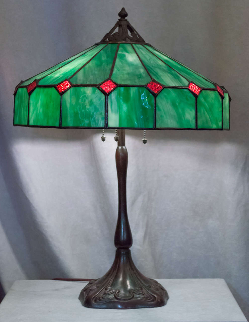 This simple yet elegant lamp was produced by the Handel Co. Both shade and base are signed. This is an earlier lamp by this company before they started to make their popular painted shades. The base is bronze, and very art nouveau in design. The