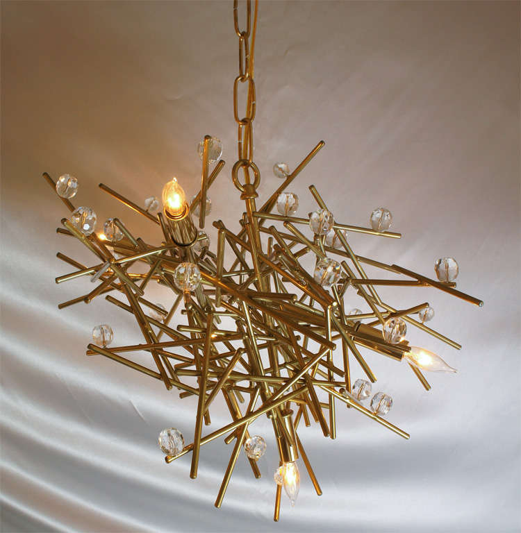 A Powder-coated Steel chandelier in Buttered Brass with crystal. Sculpture by Lou Blass - A one of a kind
