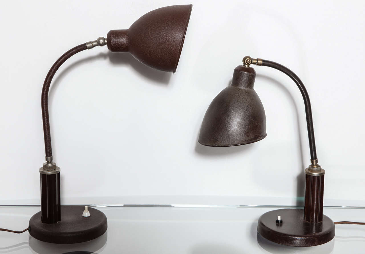 Brown painted metal with textured finish. Brass mounts and bakelite column detail. Adjustable pivoting arm and shade. These lamps are signed and well documented. Priced and sold individually.