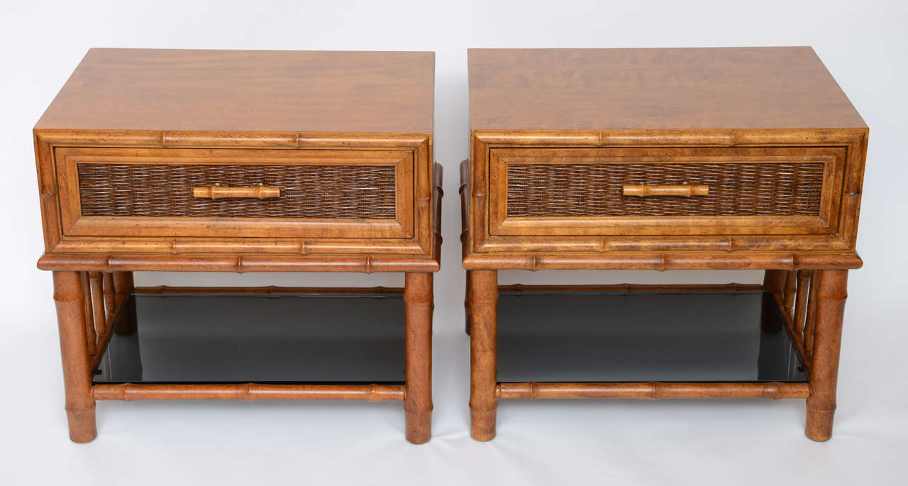 ...SOLD...Tropical or Oriental in taste, this pair of nightstands or bedside tables have a great presence and style.  Featuring a warm deep honey tone walnut body framed in shaped faux bamboo carved wood with a single drawer having a caned front and