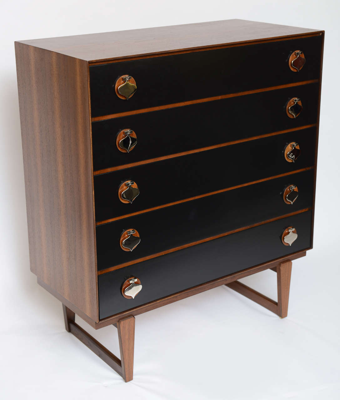 ...SOLD...Exceptional thin edge design, fine detailing and bountiful storage in this beautiful walnut five drawer dresser with unique nickel spade shaped drawer pulls and tapering sled legs.  Wonderfully figured walnut with swank black lacquered