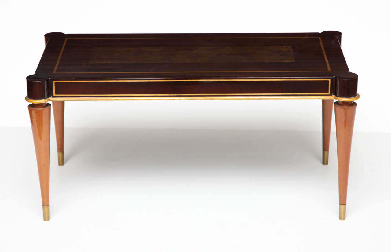 A fine mahogany coffee table by Batistin Spade, with a lacquered top and gilt bronze sabots

Signed on a metal plate under the tabletop.