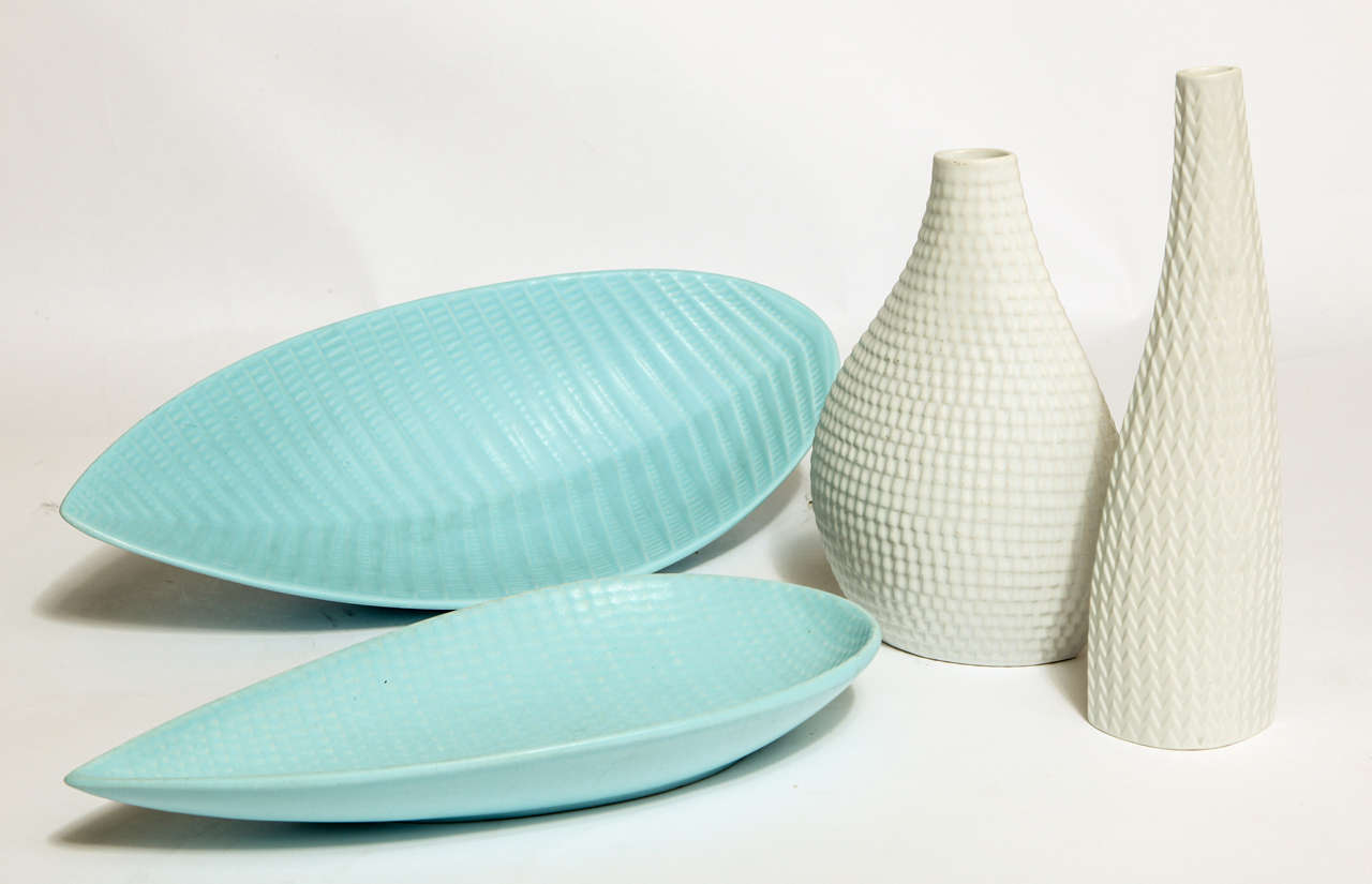 A lovely collection of Stig Lindberg ceramics from the Reptil series.
Set consists of 2 white vases and 2 pale blue bowls, all with a raised geometric pattern. Matte glaze. Incised with maker's mark and numbered. 

Tall white vase: 8.75