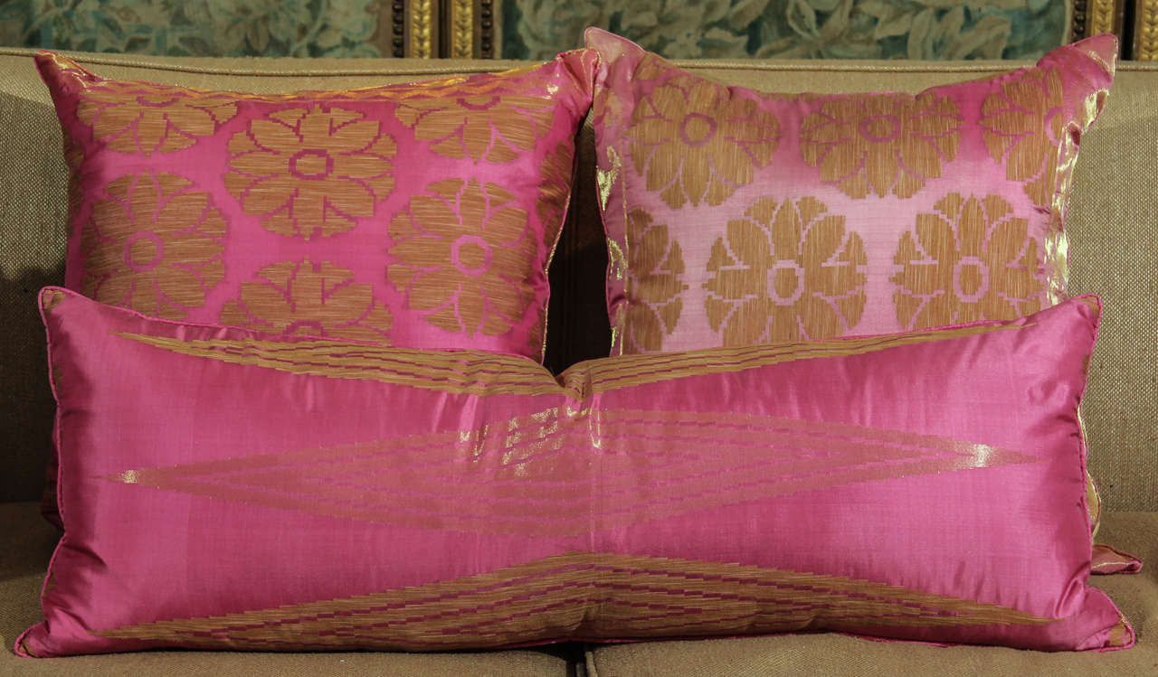Pair of pillows made from vintage pink silk sari. trimmed in gold thread and jute. down filled. One square and one long rectangle available.