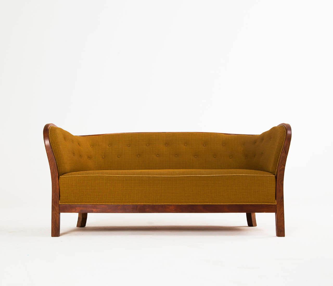Sofa, in walnut and fabric, Denmark 1940s.

Danish late art deco two-seat sofa on a beautifully curved walnut base that continues into the armrests and backrest. The original tufted ochreous fabric shows some wear due to the age and use.