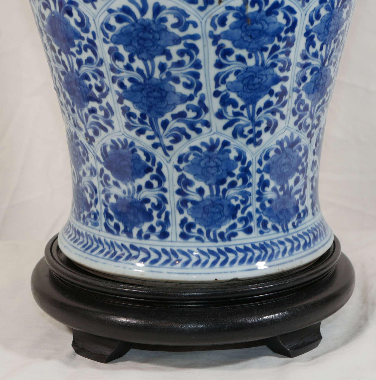 A pair Chinese Kangxi period blue and white covered vases of slender shape decorated with an all over pattern of elongated hexagonal panels with flowers painted in underglaze cobalt.