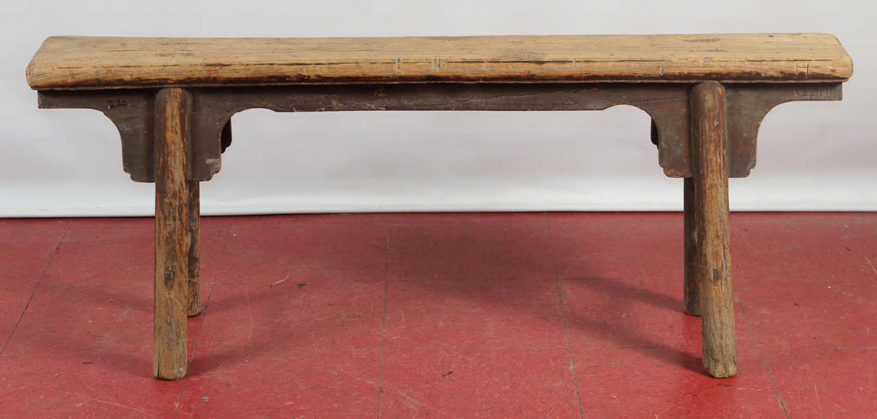 The original finish of this elm wood bench or coffee table is mostly gone leaving a beautiful natural patina.  Nothing skimpy about the solidity and thickness of the wood -- the parts of this antique bench are ingeniously joined together without