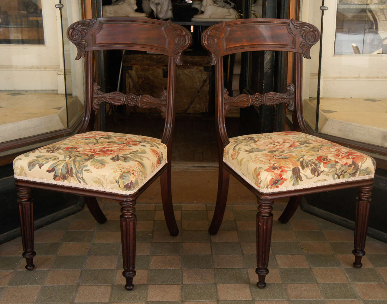 This fine pair of chairs from England  made during the William IV period show all the period's major style influences. The classical klismos profile if greatly enhanced by the carving which is cut from the solid. The crest rails tablet is enlivened