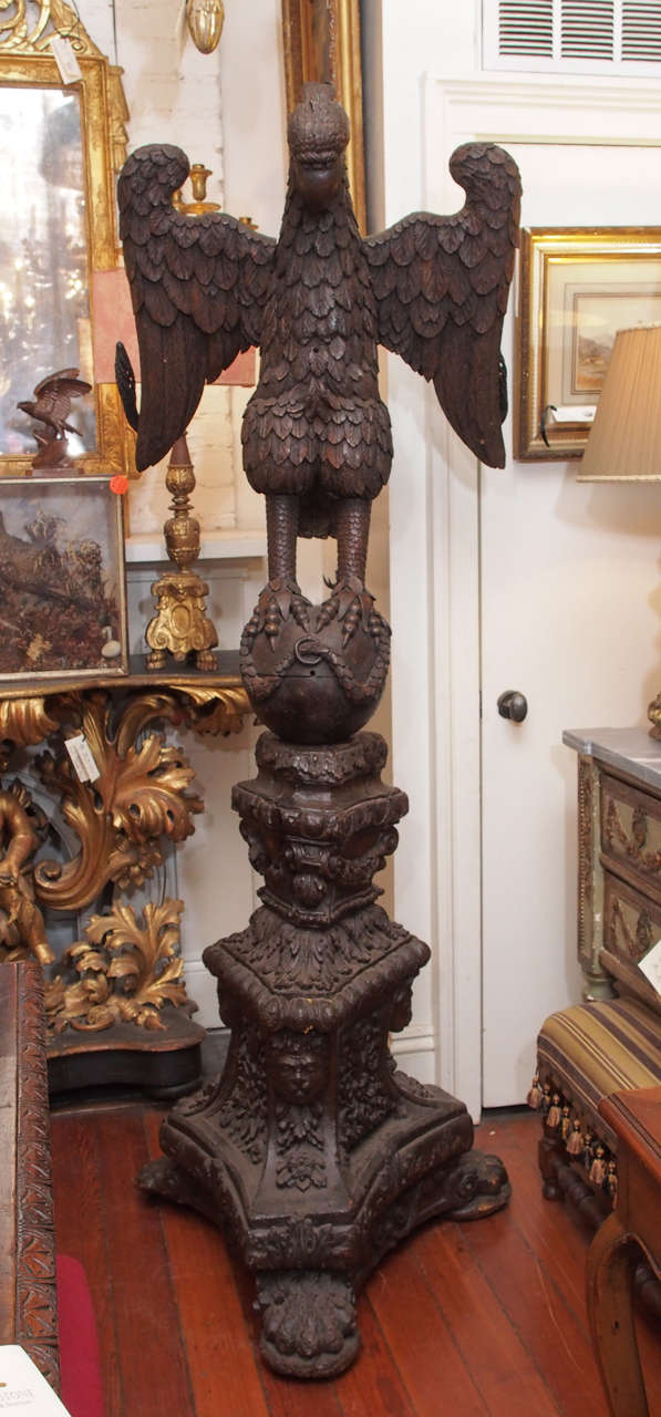 17th C. German Carved Walnut Eagle perched on the world on a plinth with foliate decoration in trifed form. The eagle swivels on the base and has two hand wrought iron movable supports for the missal.