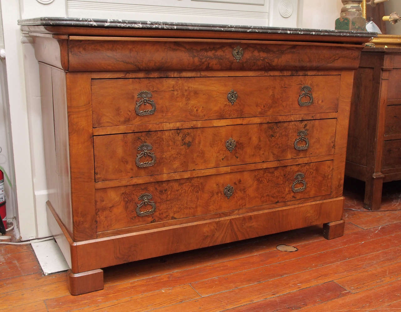 19th century Louis Philippe style  commode in burled walnut with 4 drawers . The top drawer locks  with a key. The marble top is grey and white.