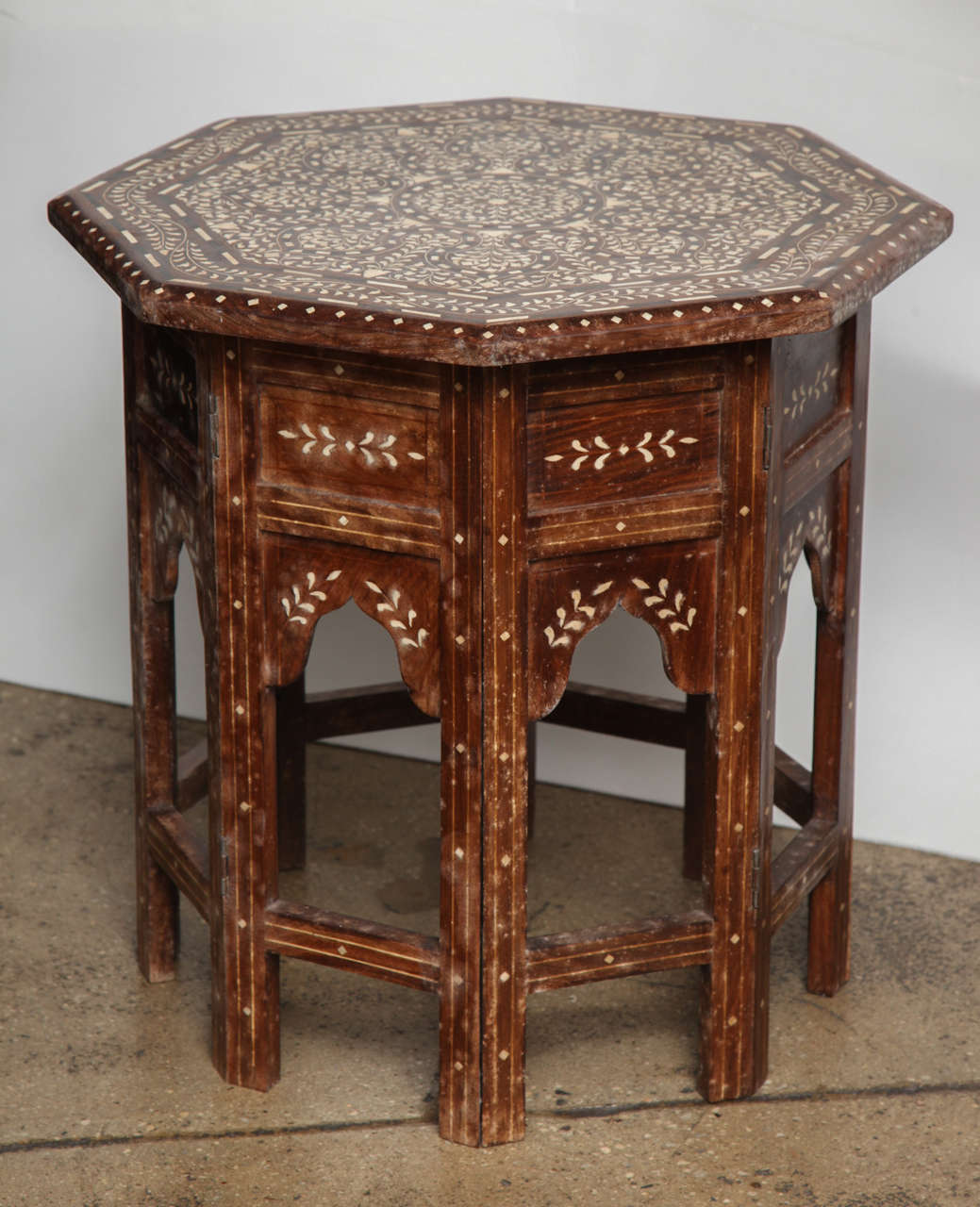 A small octagonal side table with a classic bone inlay pattern, from India.  Folding base.