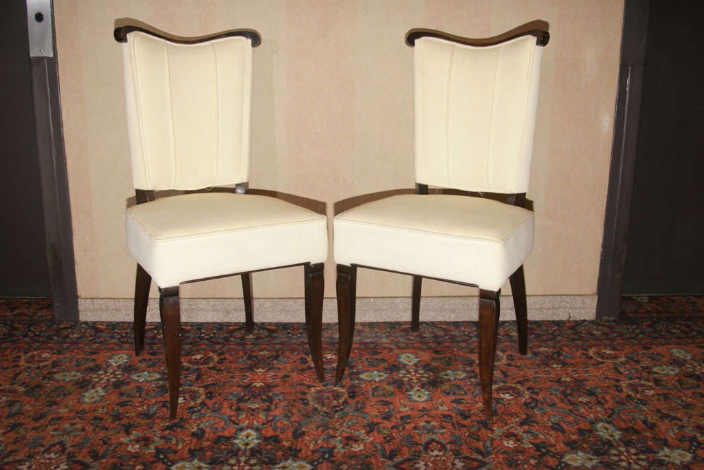 A set of six French 1940's dining chairs, with an ebonized wood frame and cream fabric upholstered.