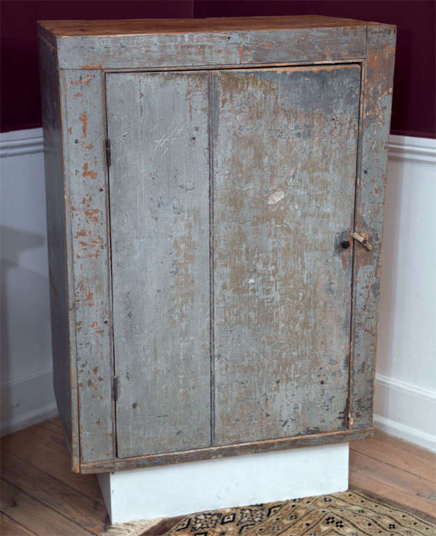 A single door wall-hung pine pantry cupboard with a fine original painted surface, wide board batten door, mortise and pin construction and two shelf interior.