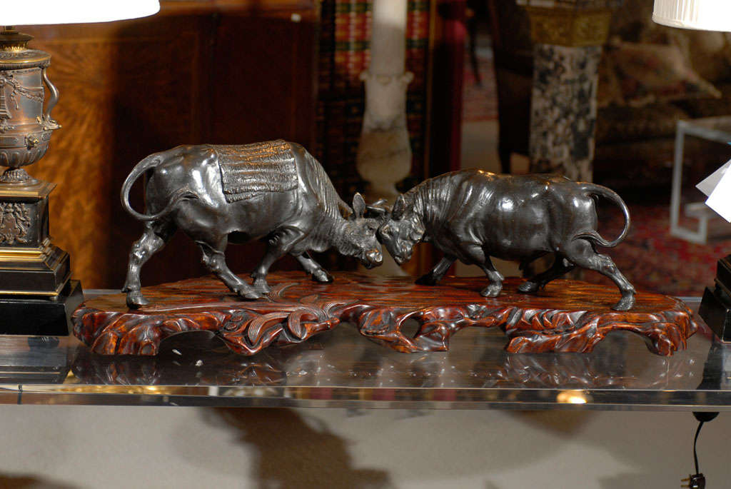 Very fine Japanese bronze of two territorial beasts, on a decoratively carved teak base. The base is 34 inches long, the bronze is 29 inches long.