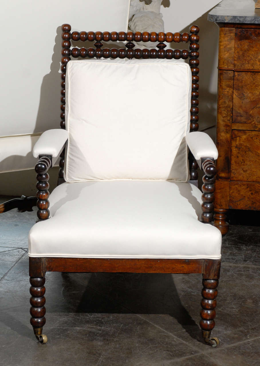 English bobbin chair with castors and detail at top.