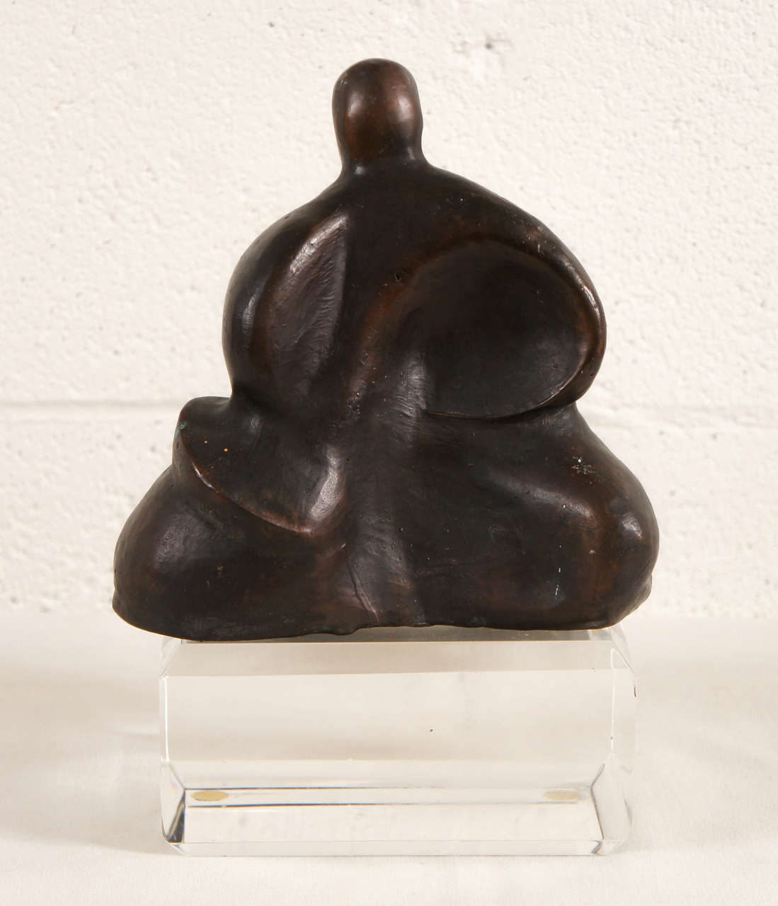 Here is a bronze sculpture of a seated figure in the style of Henry Moore. The piece is not attached to the lucite base.