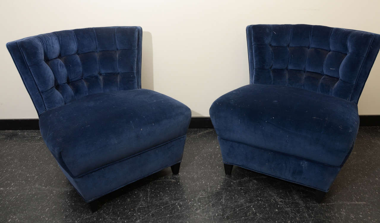 This stunning pair of tufted slipper chairs by James Mont are upholstered in a midnight blue velvet fabric.