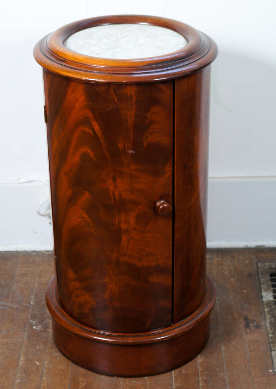 Mahogany pot table with white marble inset. One shelf in the salmon color painted interior.