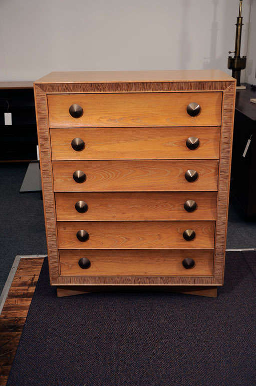 Bleached mahogany chest of drawers designed by Paul Frankl for Brown Saltman, California ca. 1940's with logo in the top drawer. Front facing rim is ribbed. Each drawer has 2 patinated brass conical form pulls.