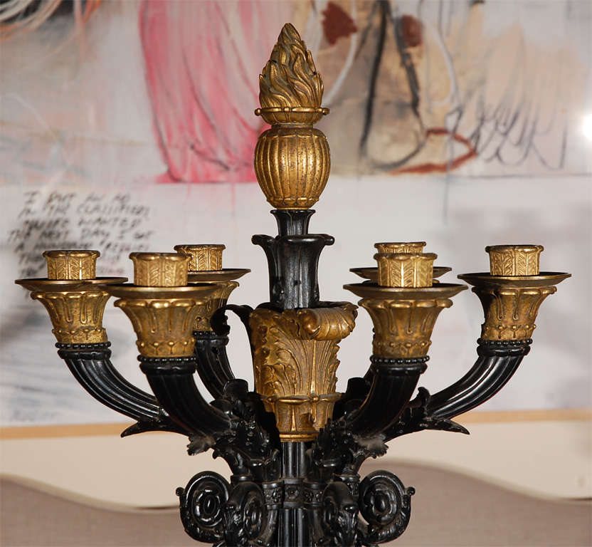 An elegant pair of 7 arm, cast metal and gilded bronze candelabra with flame finials, mounted on marble bases.  