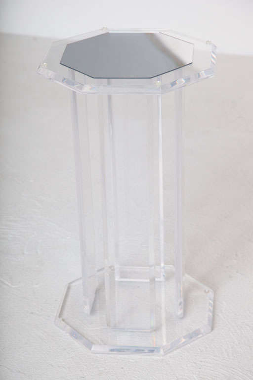 A Lucite pedestal in an octagonal shape with a mirrored top.