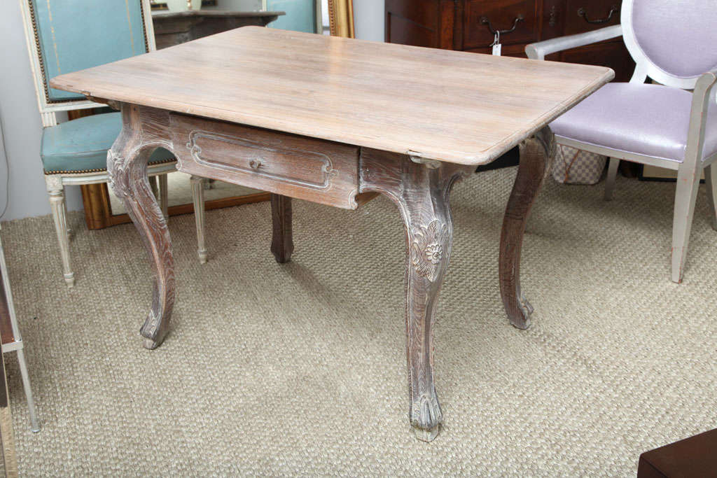 A lovely table in limed white oak with one drawer and carved cabriole legs. The table, in the Louis XV style, can be used as a desk or a small dining table.