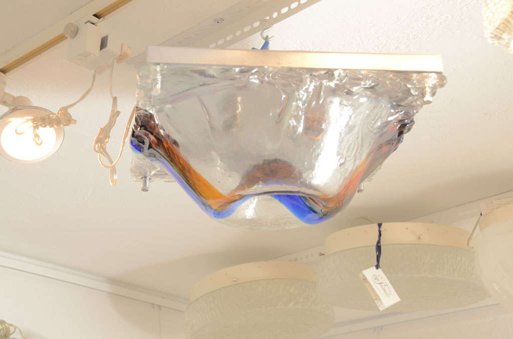 Dimpled glass flush mount ceiling fixture featuring blue and orange center stripe by Vistosi.