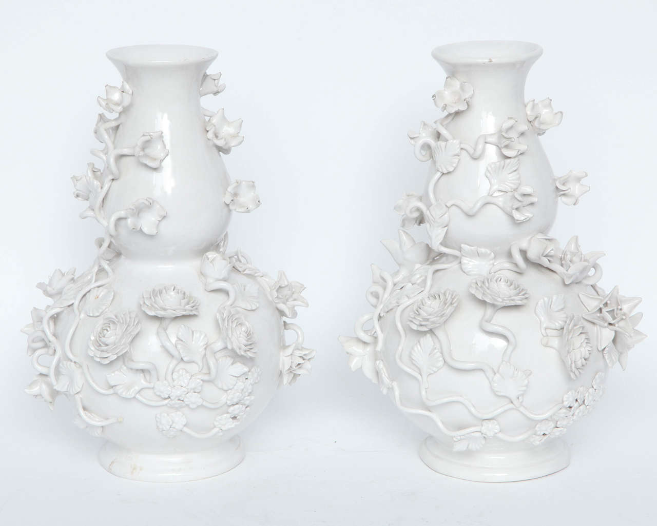 Pair of Italian blanc de chine pottery vases, 1950s. Entirely hand built with intricate applied floral decorations. Very few inconspicuous losses, in excellent condition. Each marked Made in Italy on underside.