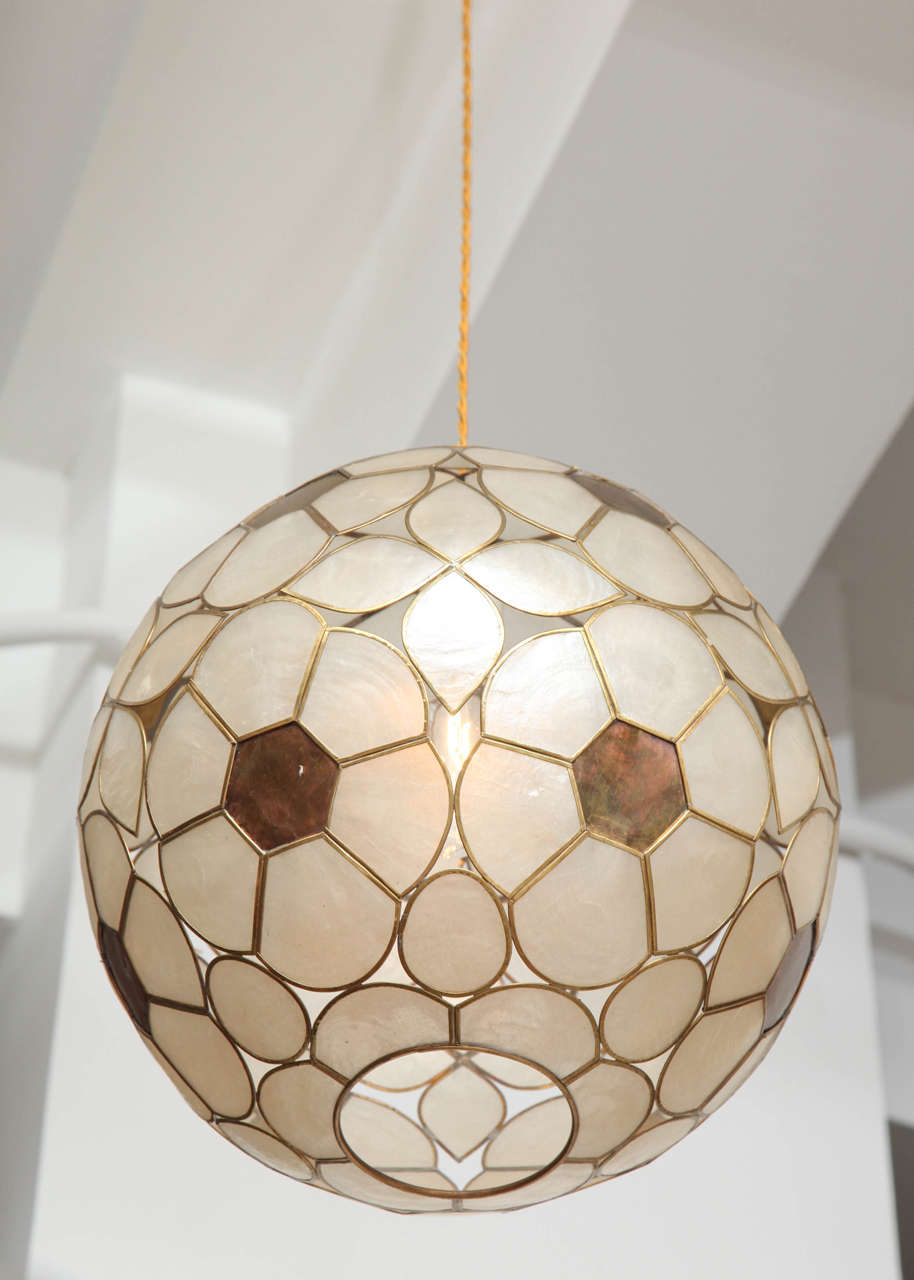 Capiz shell and brass, floral motif globe light fixture.  USA, circa 1960.  Measures 12 inches in diameter; includes 36 inches of new French gold silk twist hanging cord.  Newly rewired; takes one standard US bulb, 75 watts max.