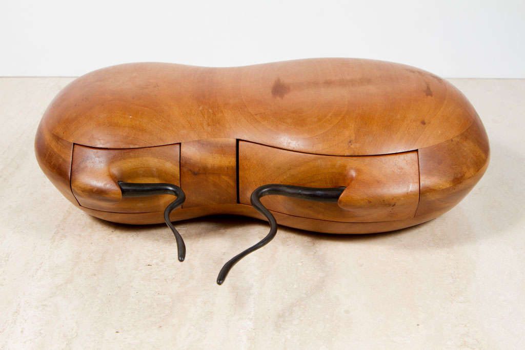 An American Studio Craft box laminated and carved from maple wood in the shape of a peanut with two drawers fit with sinuous wrought iron pulls. Measurements: The depth is 10 for the box and 14.5 including the pulls. Stamped to the base [Kovach