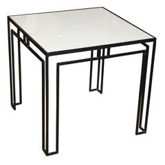 Black wrought iron table with white glass top by Tommi Parzinger