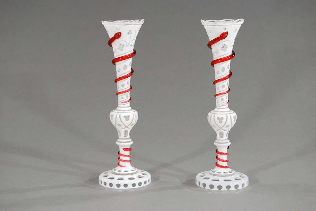 This beautifully matched pair of 19th c vases are cased in white crystal and cut to clear in an all-over pattern decorating the vases from the petal rims to the raised foot. Completing the picture, they are encircled with applied cranberry crystal