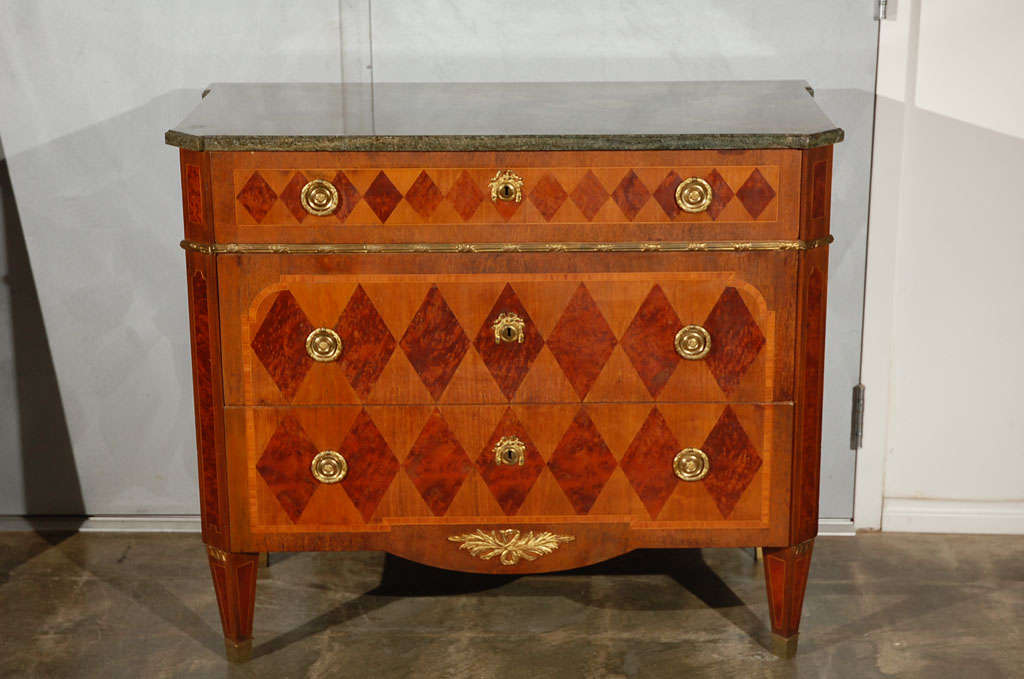 An excellent example of design and craftsmanship. This Swedish commode has a very nice marble top and brass decorative elements, escutheons and ring pulls. The piece has diamond marquetry in contrastive burled walnut on the three drawers and