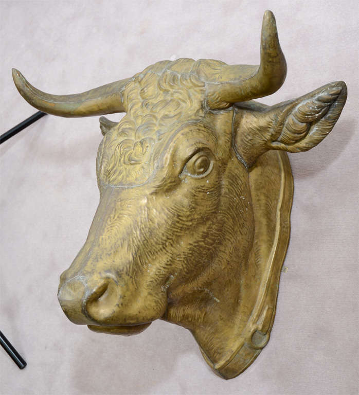 A turn of the century butcher's trade sign in the shape of a bulls head in gilded metal. The piece is stamped 