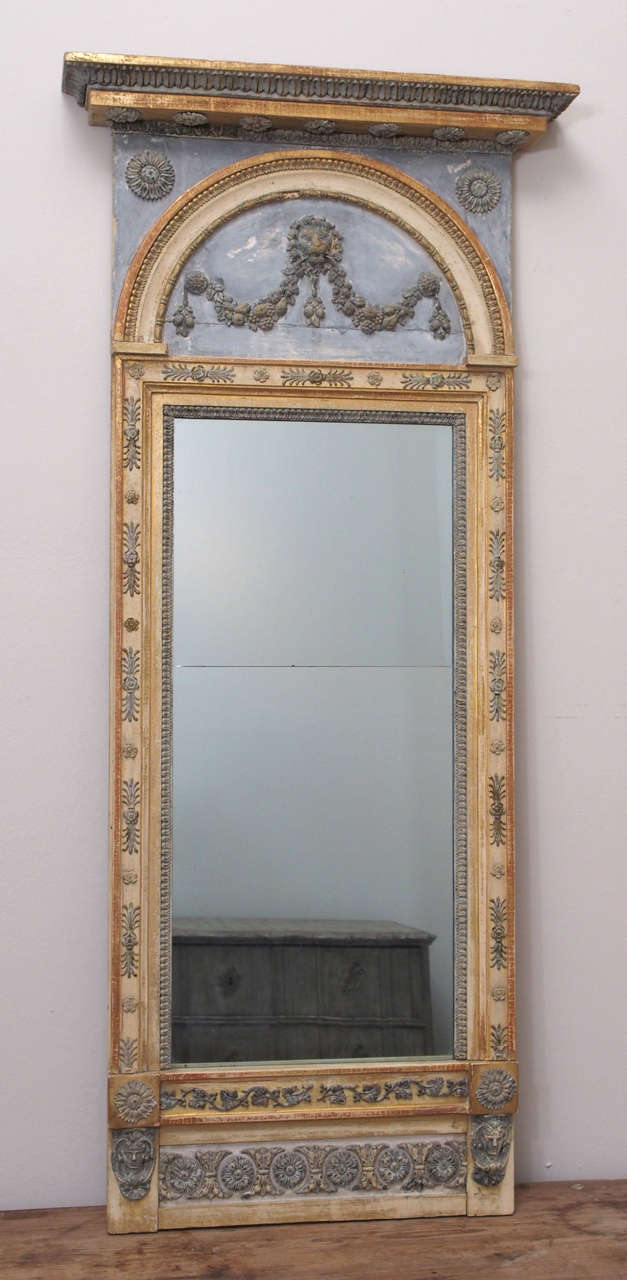 Very fine Swedish mirror with painted overpanel featuring a lion head and garlands of fruit on a pale blue-grey ground.  Painted and gilded frame with a Stockholm maker's label 