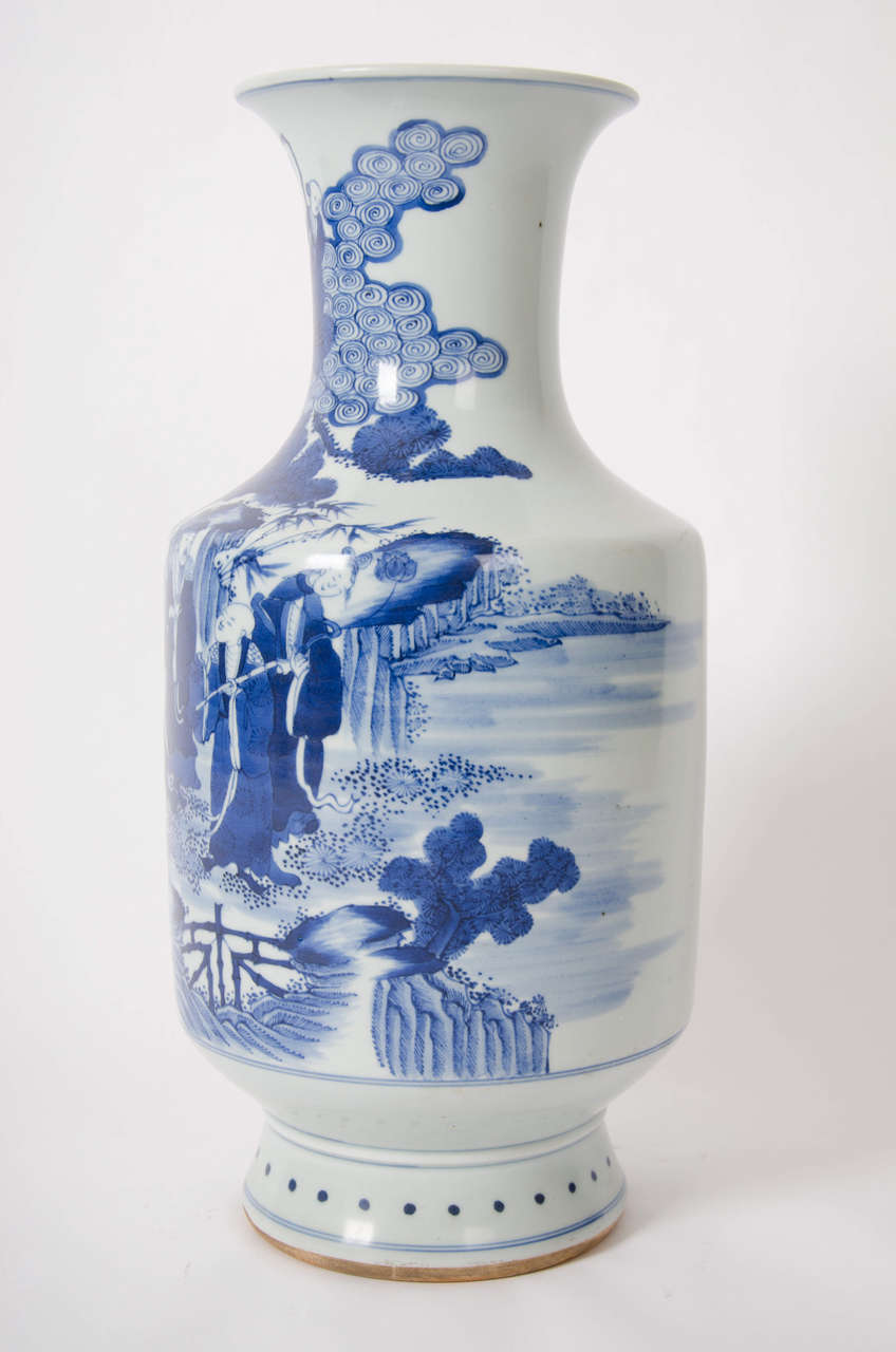 This is a fine quality BEAKER shaped VASE made in China.
 
The vase is porcelain, with a flaired rim and bulbous beaker body.

It is beautifully painted, under-glaze, in different shades of cobalt blue decoration, showing various figures in a