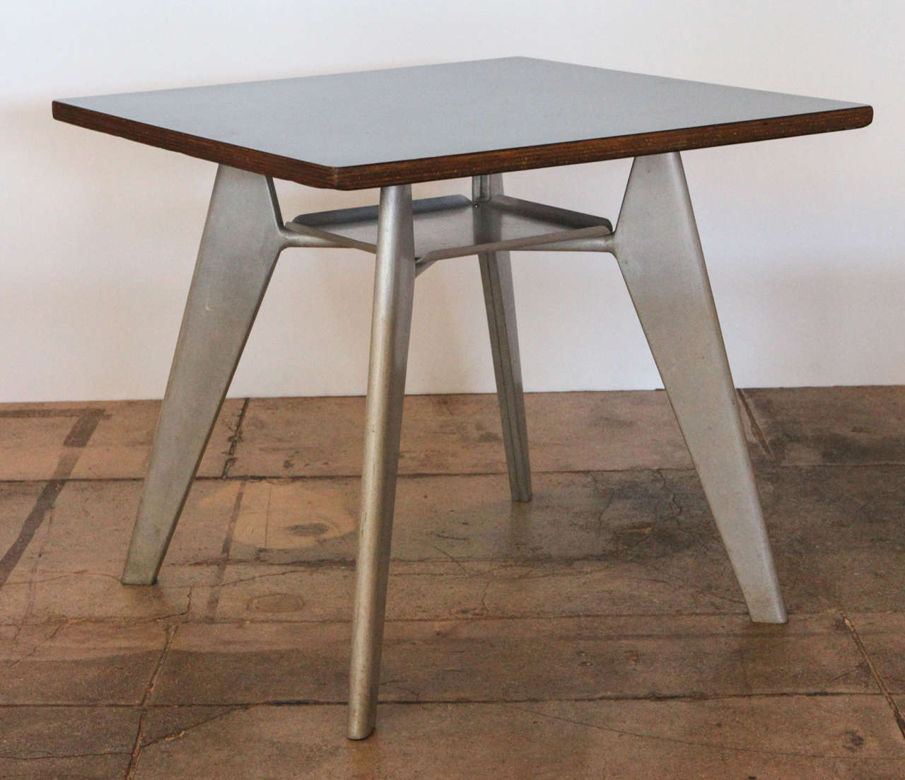 jean prouve's cafeteria table , no. 511 , with original aluminum base & black formica top.