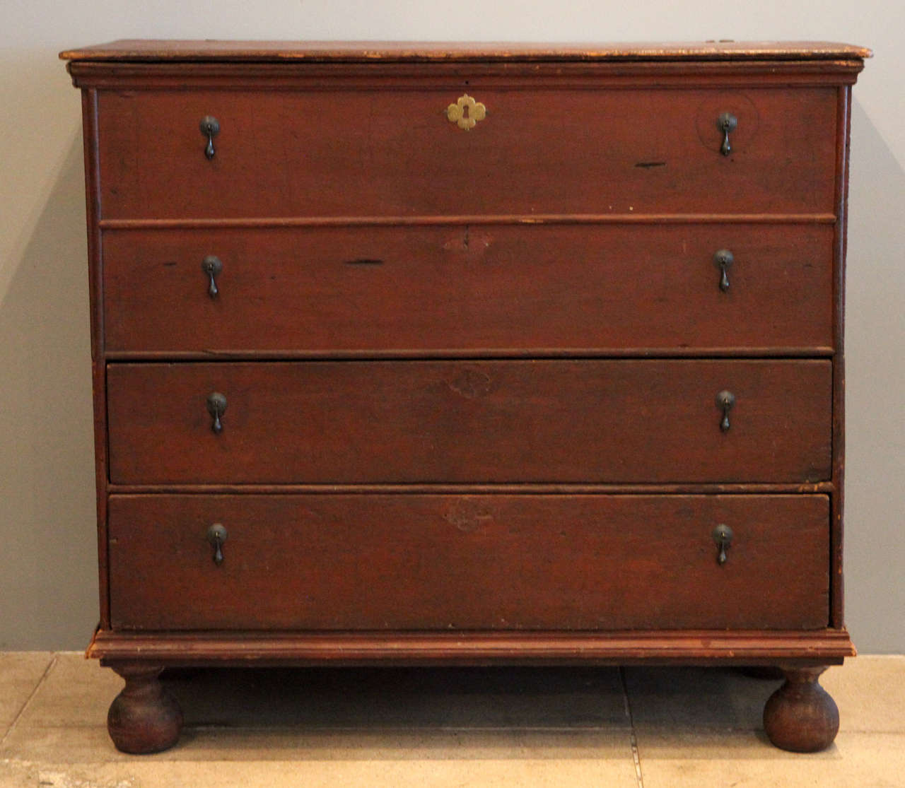 a handsome chest of drawers from new england with two lower drawers and a hidden compartment for the upper two . the original ball shaped feet are pretty exquisite. perfect in a contemporary environment.